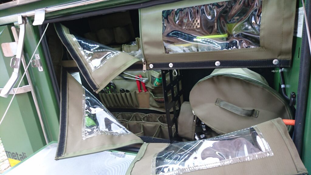 Custom Canvas Zipped Flipup lid inserts, Shelf flaps with clear PVC windows, cutlery caddie and zipped canvas bag to hold pots and pans in the kitchen hatch of a Metalian Maxi.