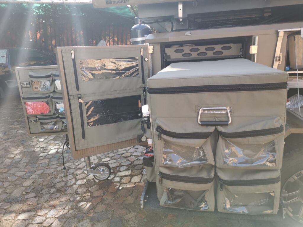 Custom Shelf flaps and Fridge cover to hold spices and condiments, plastic bags and other random items fitted to a Metalian Maxi camping trailer.
