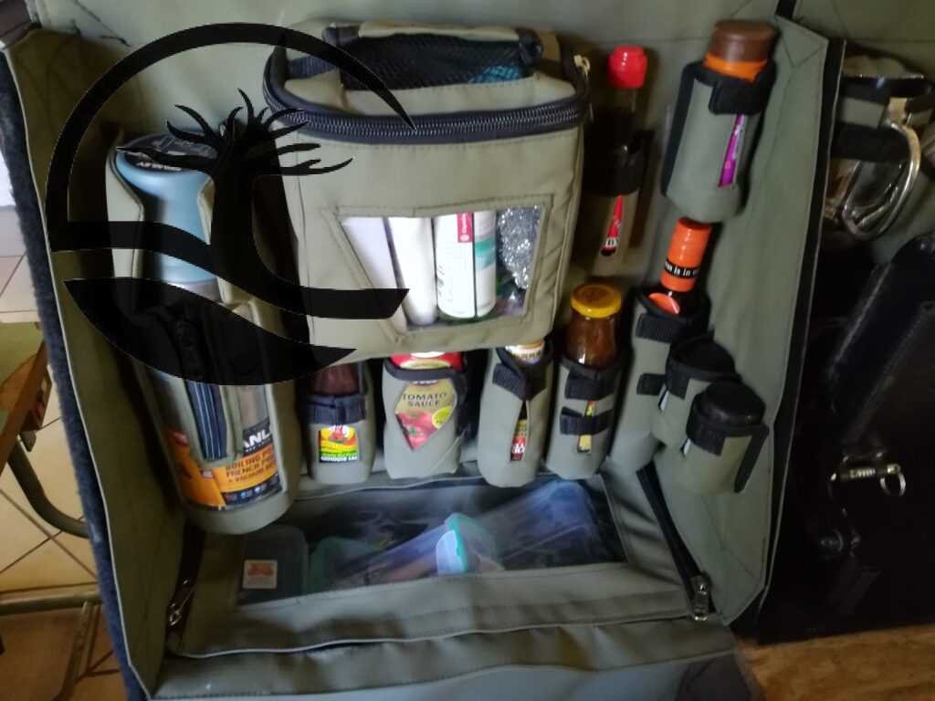 Custom Canvas Caddie to hold dishwashing essentials, a Stanley flask, condiments and spices with a dropdown bag to store grocery items fitted to an aluminum Bakkie canopy.