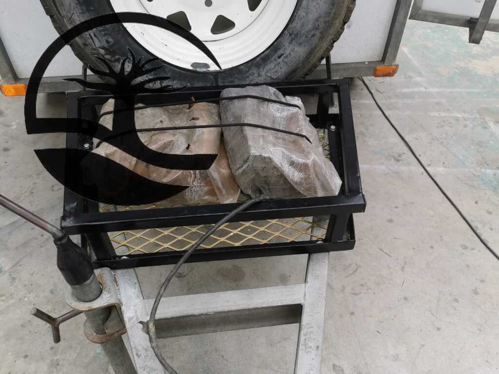 Custom Steel carrier for firewood mounted on the front A-frame of a Buzzard Camping Trailer.