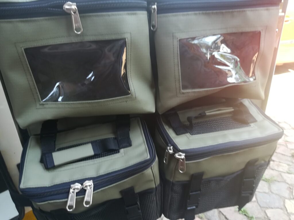 Custom Canvas caddie with zipped bags with PVC windows and removable shower bags installed into the front tent side door of a Jurgens XT camping trailer.